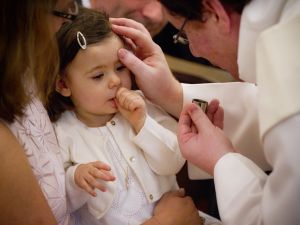 Le signe de croix sur le front de l’enfant baptisé