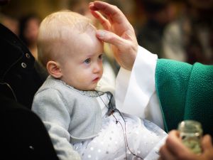 Le signe de croix sur le front de l’enfant baptisé