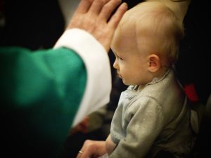 Le signe de croix sur le front de l’enfant baptisé